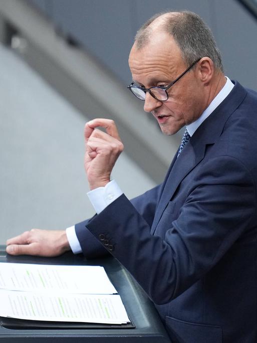 CDU-Kanzlerkandidat Friedrich Merz bei einer Rede im Deutschen Bundestag am Rednerpult. Mit einer Geste seiner Hand betont er seine Worte.