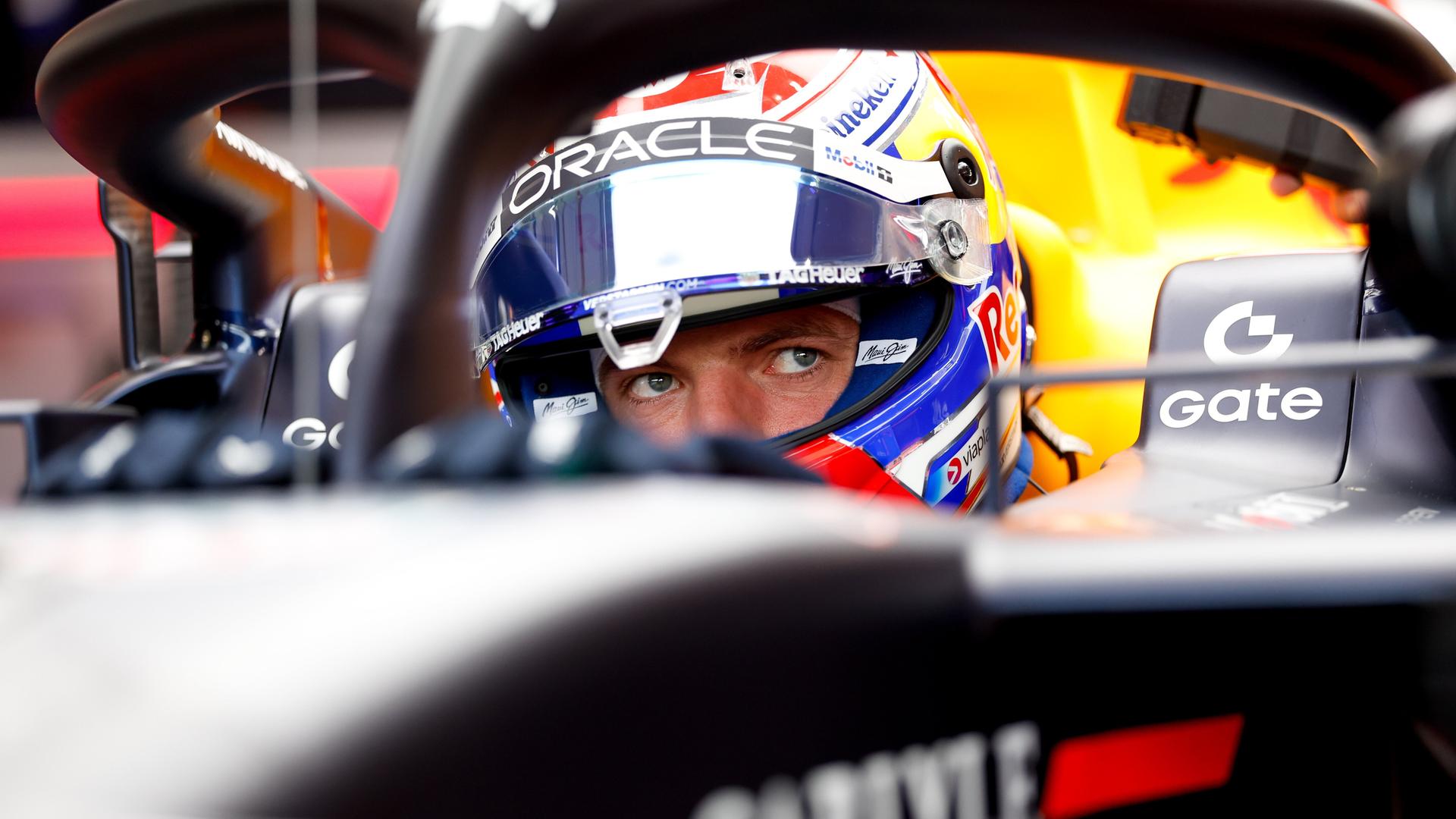 Formel 1-Pilot Max Verstappen mit Helm in seinem Rennauto
