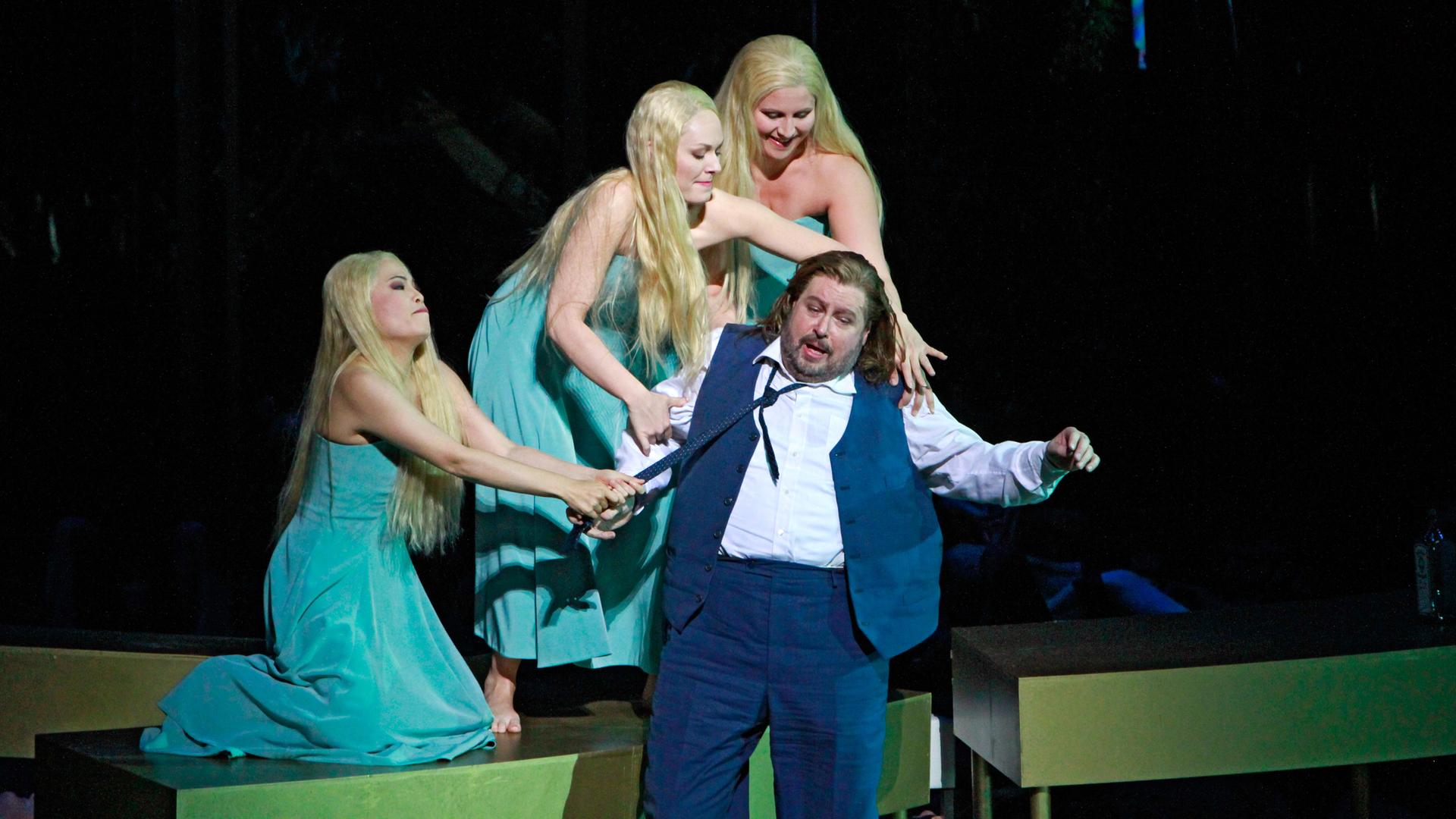 Auf der Bühne der Staatsoper München während der "Götterdämmerung"-Aufführung: Ein Mann wird von drei Frauen gezogen.