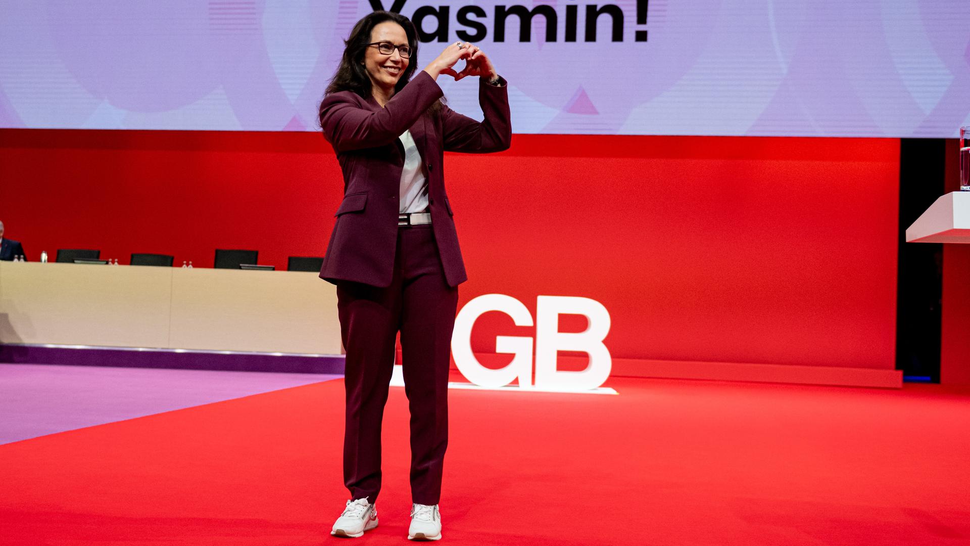 Yasmin Fahimi, DGB-Chefin, steht nach ihrer Wahl auf der Bühne und formt mit den Händen ein Herz in Richtung der Delegierten des Bundeskongresses. Yasmin Fahimi, DGB-Chefin, steht nach ihrer Wahl auf der Bühne und formt mit den Händen ein Herz in Richtung der Delegierten des Bundeskongresses.