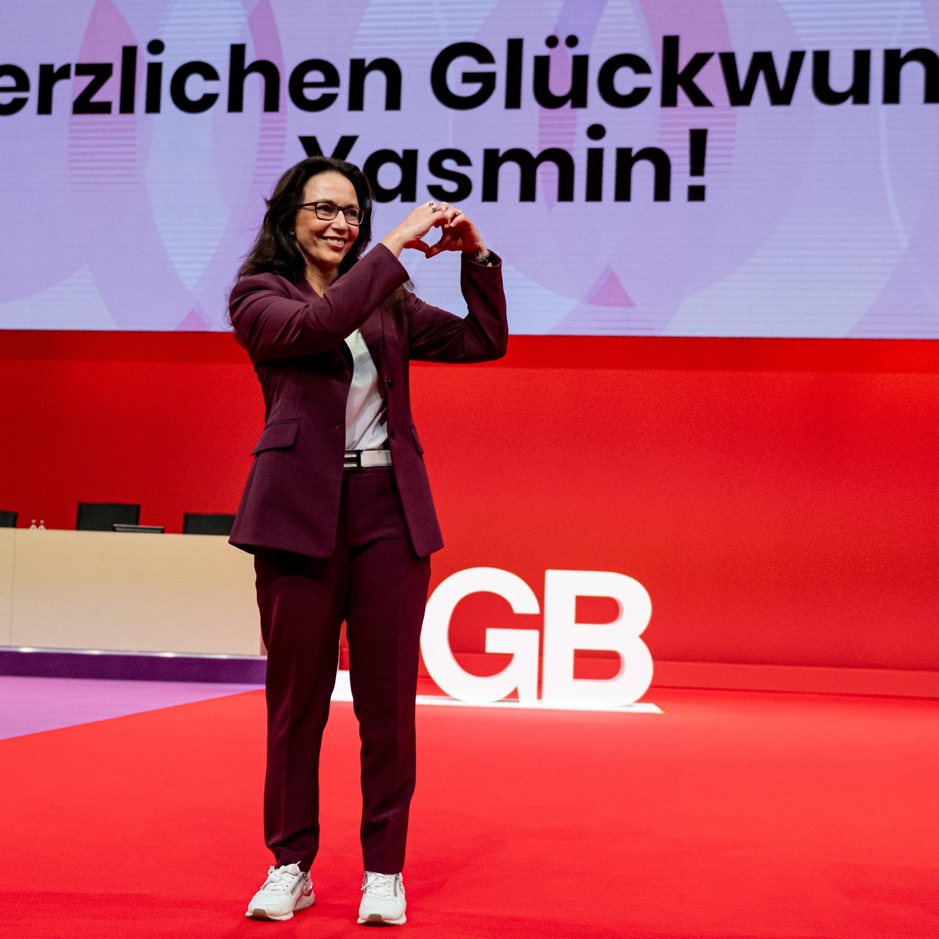 Yasmin Fahimi, DGB-Chefin, steht nach ihrer Wahl auf der Bühne und formt mit den Händen ein Herz in Richtung der Delegierten des Bundeskongresses.