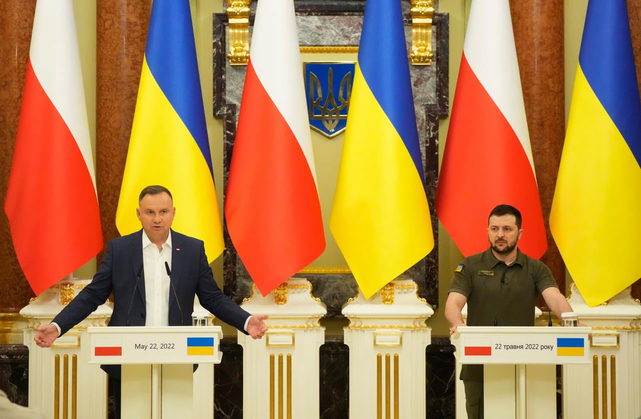 Der polnische Präsident Duda (links) und der ukrainische Präsident Selenskyj stehen vor großen Fahnen der beiden Länder an Stehpulten am 22.05.2022.