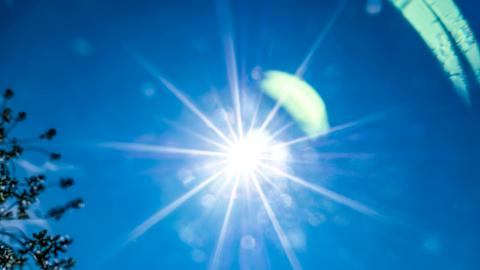 Die Sonne flimmert am blauen Himmel.