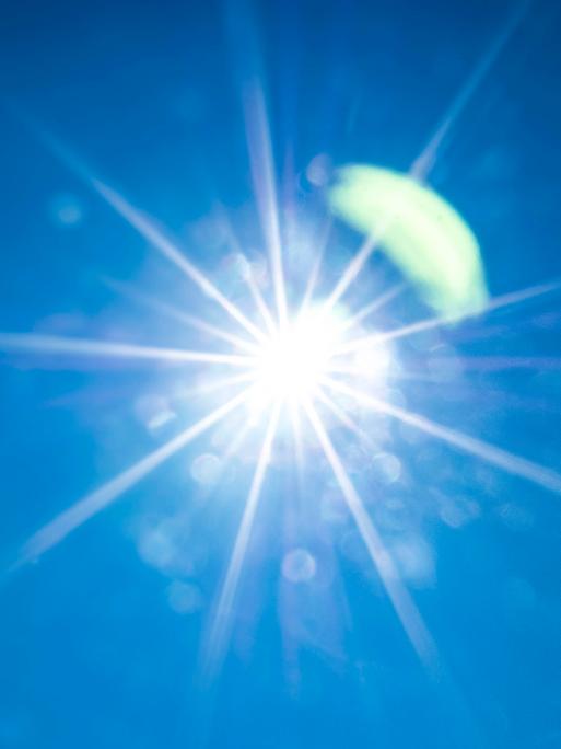 Die Sonne flimmert am blauen Himmel.