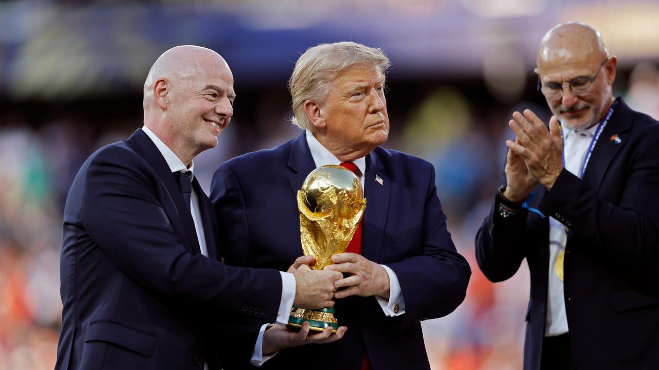 Gianni Infantino und Donald Trump halten bei der Siegerehrung der FIFA WM 2026 den Pokal in Händen, abseits steht der Trainer der siegreichen spanischen Nationalmannschaft Luis de la Fuente.