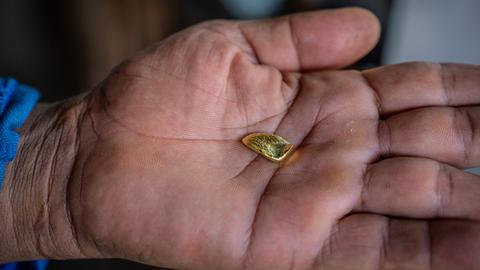 Ein Stück Gold in einer Handfläche eines Menschen