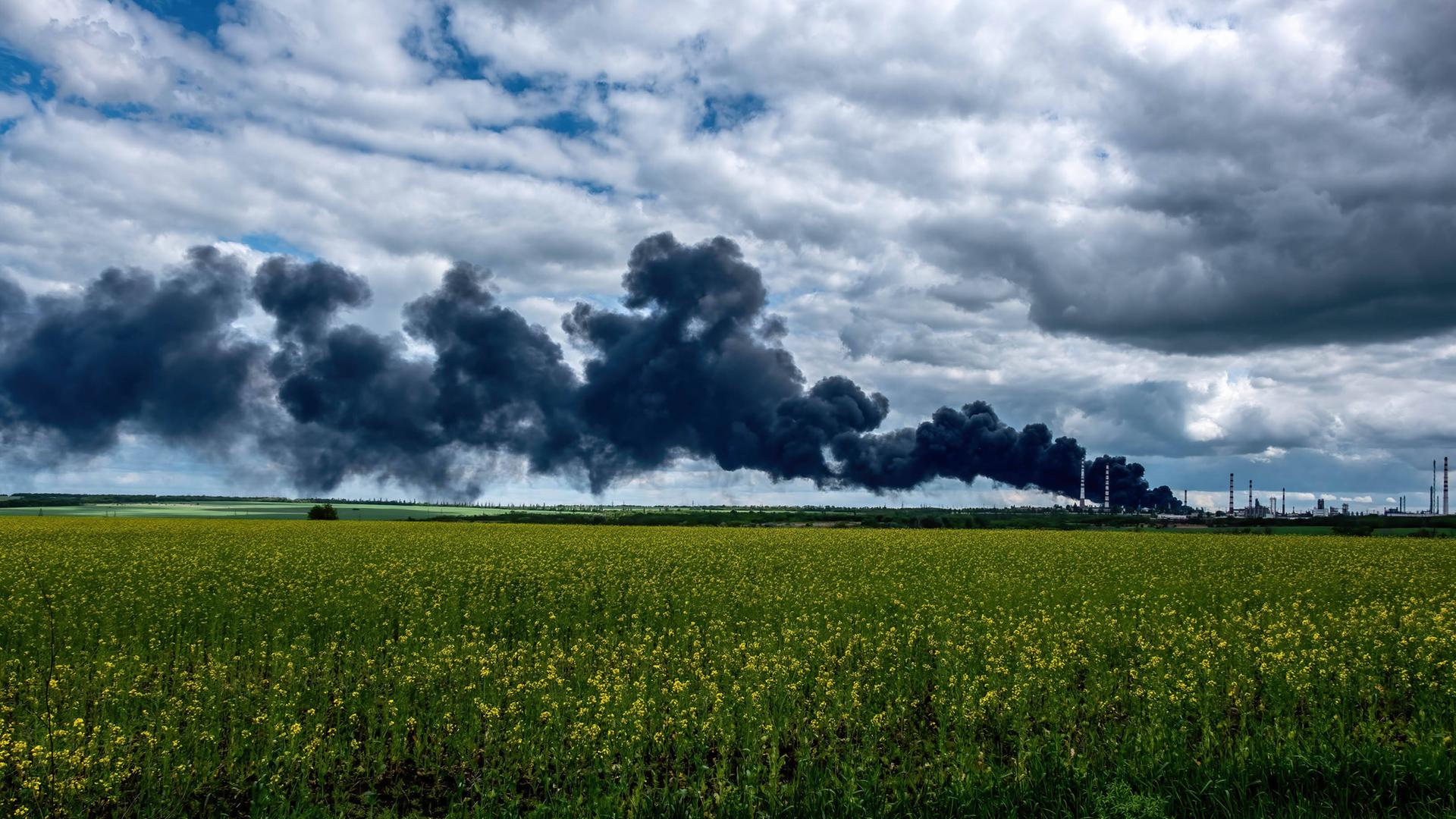 Rauch steigt in den Himmel, nachdem russische Granaten die Ölraffinerie von Lyssjansk getroffen haben.