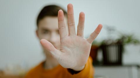 Ein junger Mann hält seine Kamera, sein Gesicht ist dadurch verdeckt