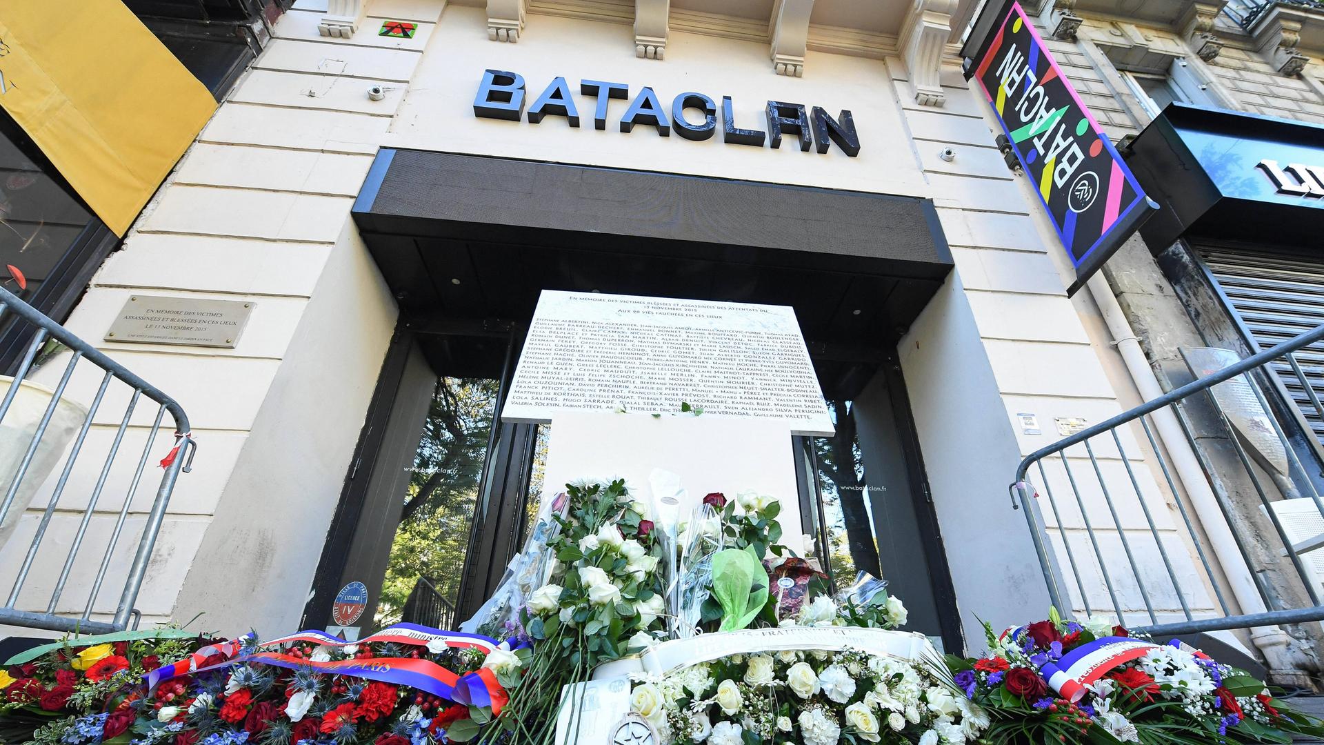 Blumen und eine Gedenktafel vor dem Konzerthaus Bataclan.