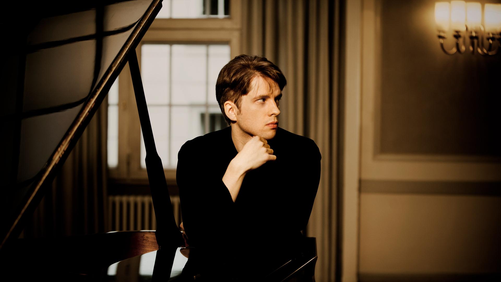 Der Pianist Severin von Eckardstein hinter einem schwarzen Flügel. Der Pianist Severin von Eckardstein hinter einem schwarzen Flügel.