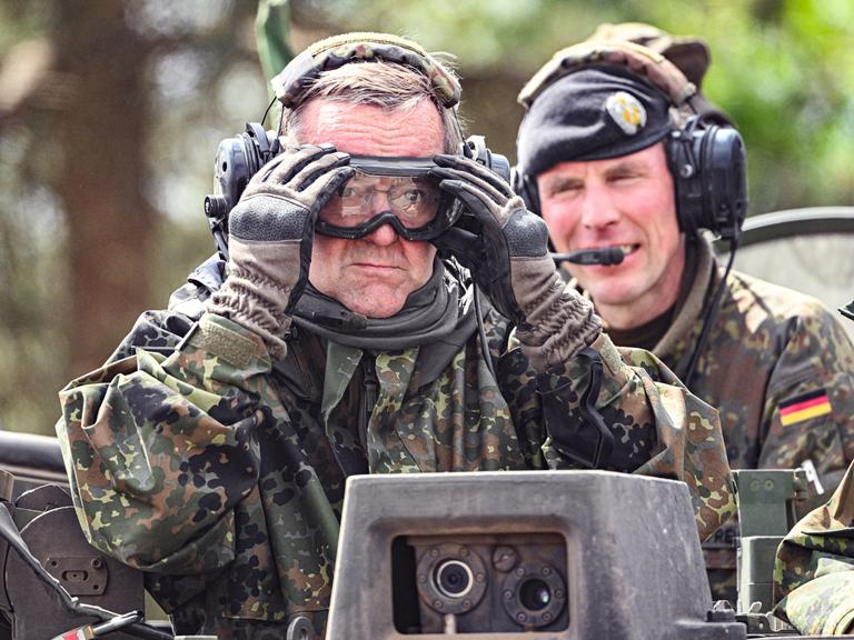 Verteidigungsminister Boris Pistorius in Bundeswehr-Kleidung, mit Handschuhen und Schutzbrille.