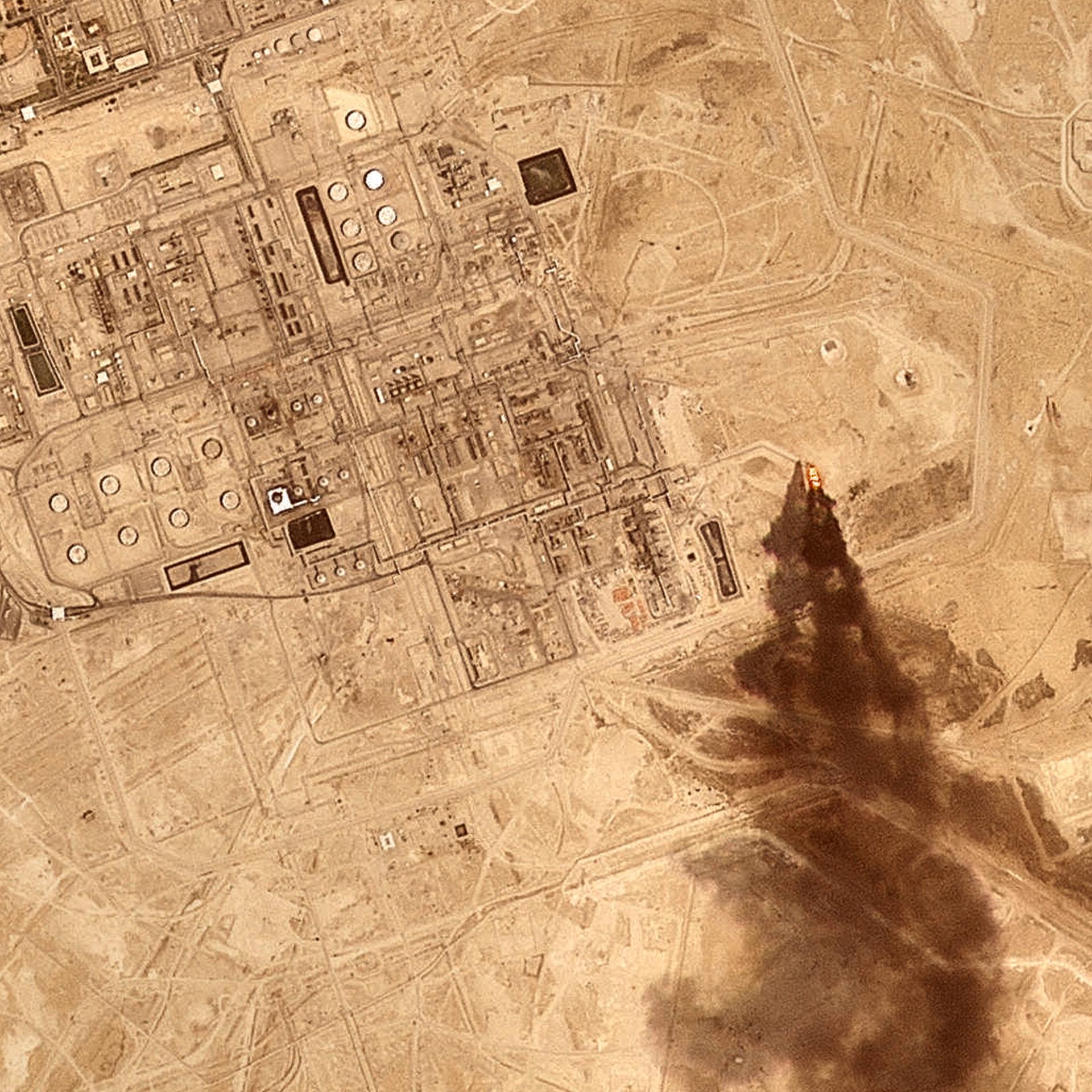 Ein Satellitenbild zeigt eine Raffinerie des saudischen Ölkonzerns Aramco, an deren Rand eine große Rauchwolke nach einem Drohnenangriff aufsteigt.