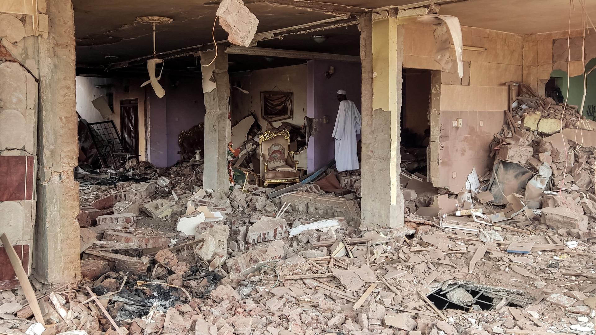Ein Mann geht durch ein zerstörtes Haus in Karthum im Sudan.