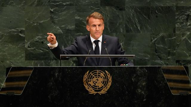 Der französische Präsident Macron steht am Rednerpult und gestikuliert. 
