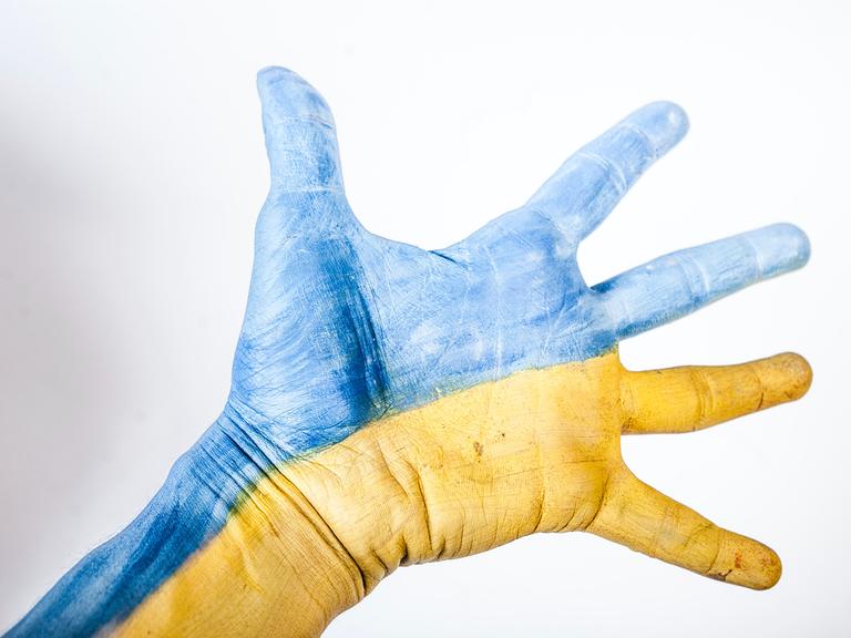 Eine Hand in den Farben der ukrainischen Flagge.