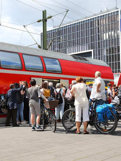 Fahrgäste warten in einer Schlange am Bahnsteig des Karlsruher Hauptbahnhofs auf den Einstieg in den Regionalexpress.