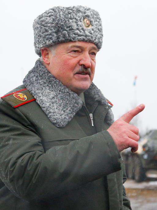 Der belarussische Präsident Alexander Lukaschenko gestikuliert, während in der Nähe von Osipovichi, Belarus, auf dem Übungsgelände Osipovichi mit Journalisten spricht. Er trägt eine Fellmütze und eine Uniform mit Fellkragen.