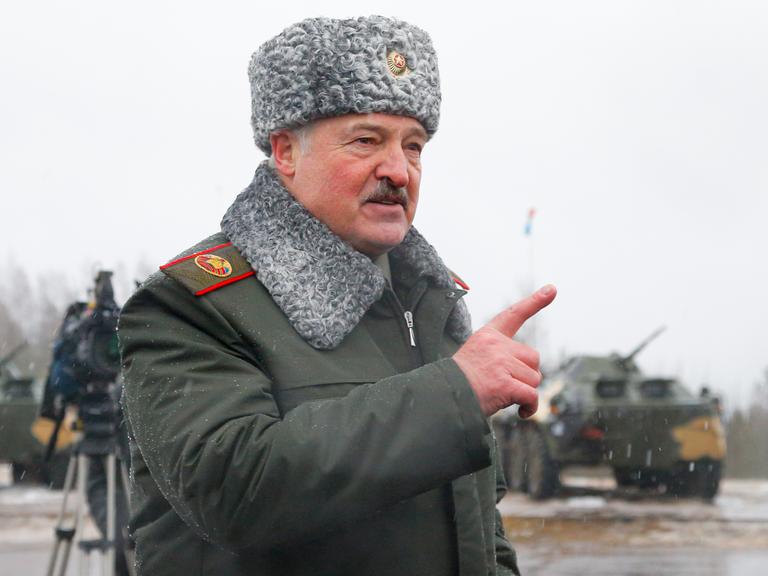 Der belarussische Präsident Alexander Lukaschenko gestikuliert, während in der Nähe von Osipovichi, Belarus, auf dem Übungsgelände Osipovichi mit Journalisten spricht. Er trägt eine Fellmütze und eine Uniform mit Fellkragen.