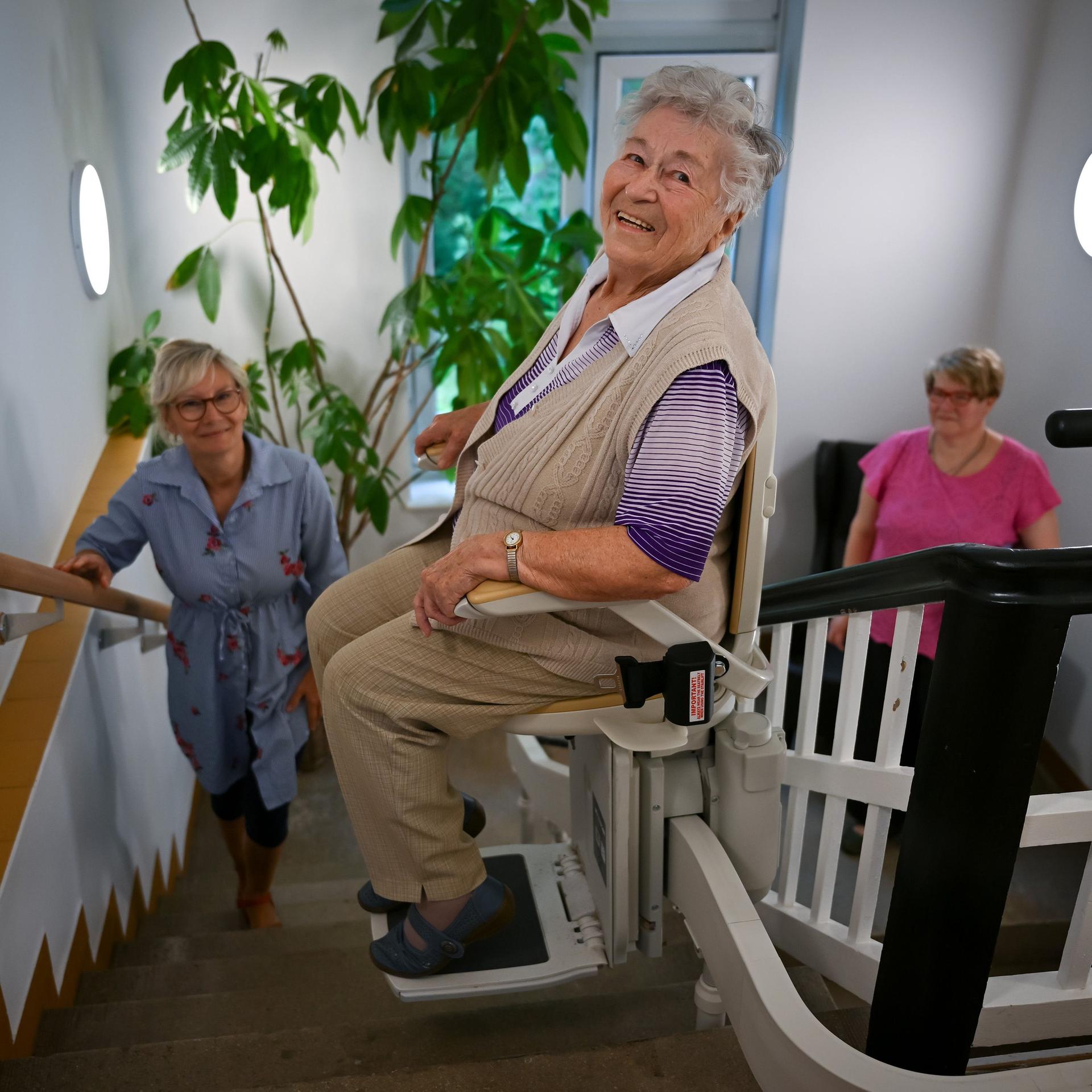 Brandenburg, Wiesenburg: Isa Paul (92), Bewohnerin der Senioren-Wohngemeinschaft des DRK, fährt mit einem Treppenlift in die obere Etage des Hauses. Neun Seniorinnen und Senioren haben in der Wiesenburger Parkstraße in Nachbarschaft zum Schlosspark ihr Zuhause gefunden. In der Wohngemeinschaft haben sie die Möglichkeit, mit Hilfe des DRK-Pflegeteams ihren Alltag zu gestalten.
