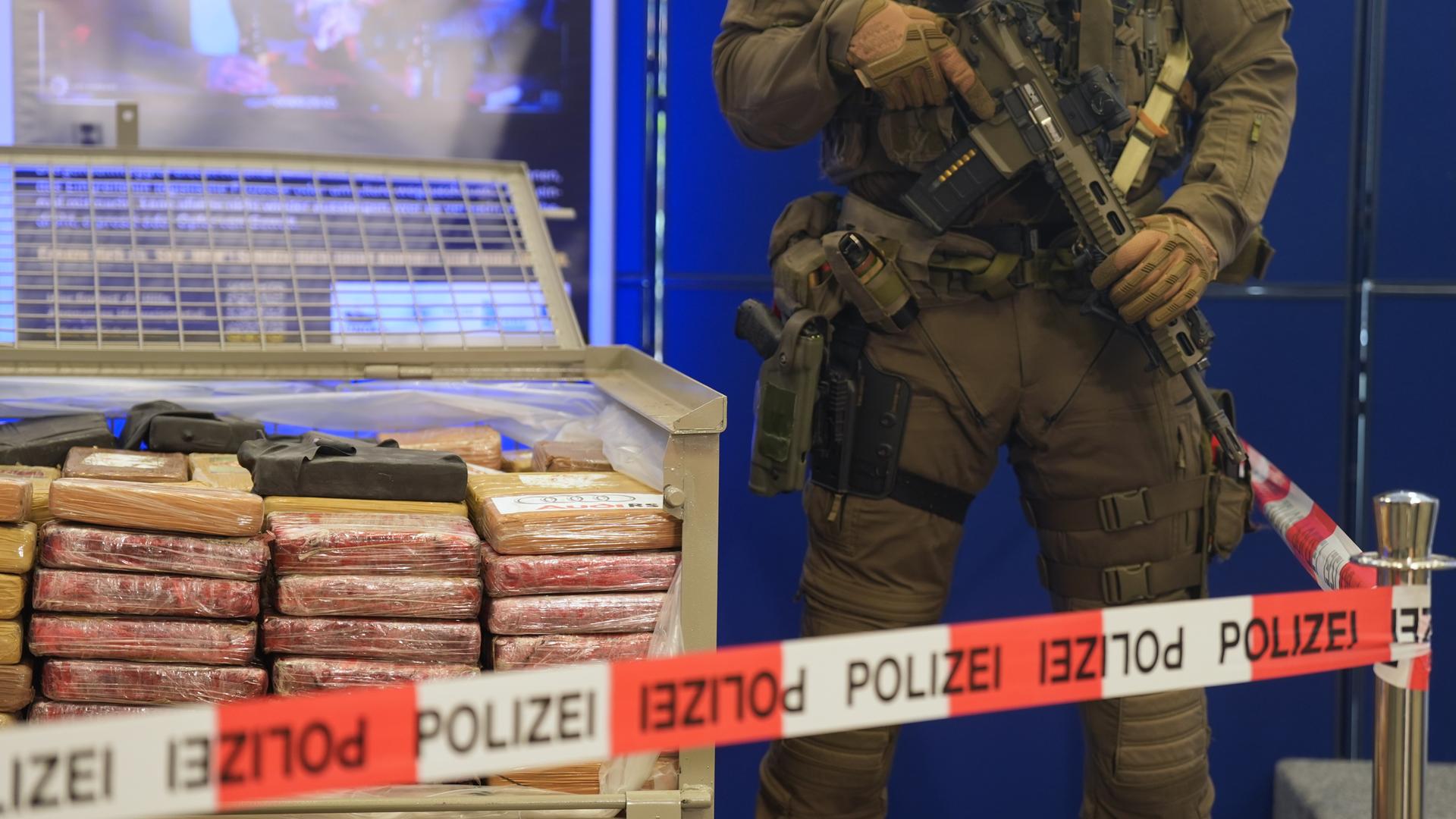 Schwer bewaffnete Spezialkräfte der Polizei sichern während einer Pressekonferenz im Polizeipräsidium sichergestellte Päckchen mit Kokain.