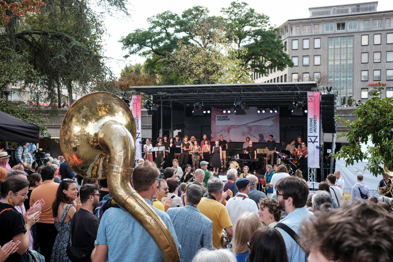 Blich auf eine Openair-Bühne in Köln, davor viel Publikum. Ein Mann hat sogar ein Sousafon dabei.