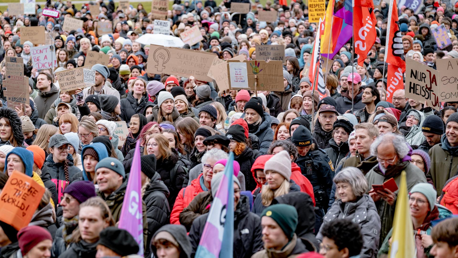 Menschen demonstrieren auf dem Königsplatz in München gegen sexualisierte Gewalt. Sie halten Schilder hoch, darauf zu lesen zum Beispiel "Nur Ja heißt Ja". 