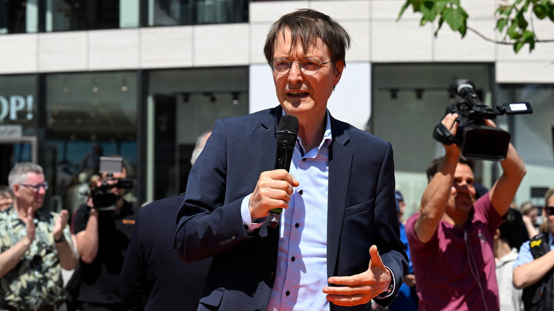 Karl Lauterbach eröffnet den 41. Tag der Organspende auf dem Schadowplatz in Düsseldorf. Er spricht in ein Mikrofon. Hinter ihm sind viele Kameras zu sehen.