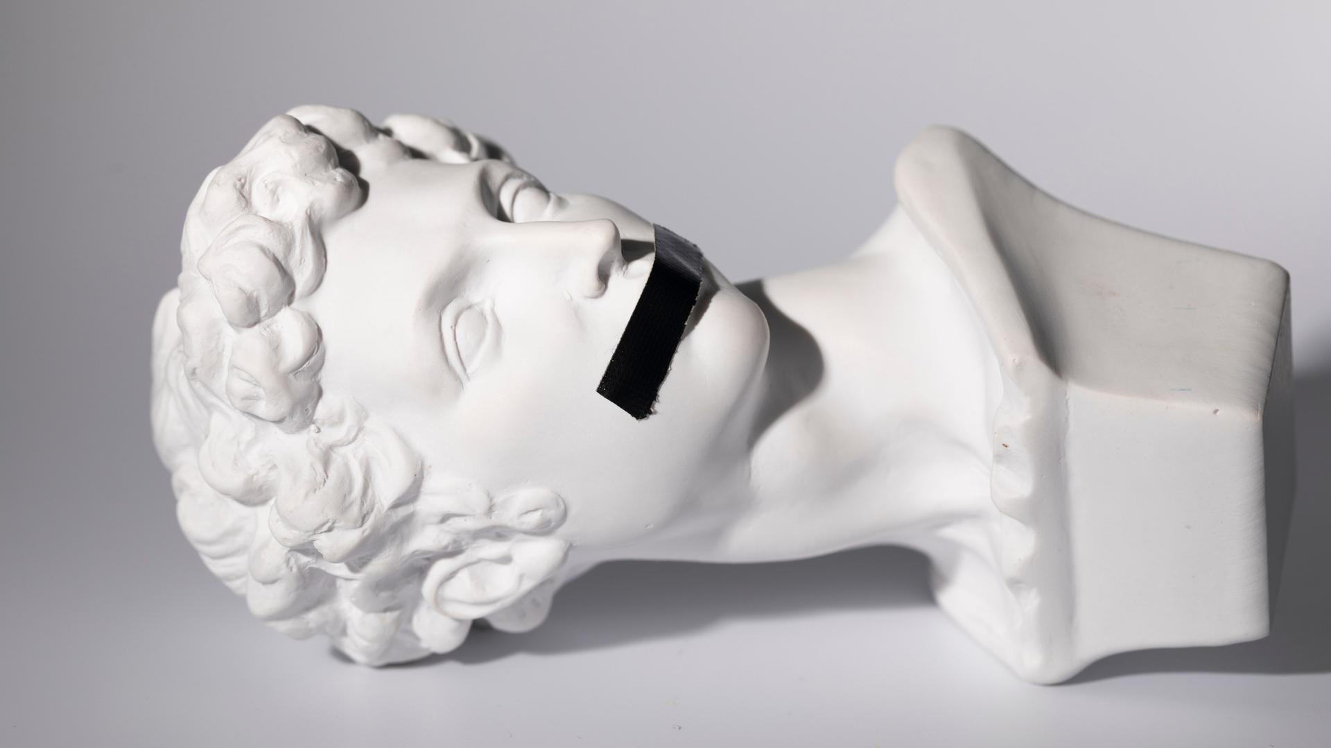 Antike Kopfskulptur von Giuliano de' Medici, geschaffen von Michelangelo Buonarroti im 16. Jahrhundert, mit schwarzem Klebeband über dem Mund