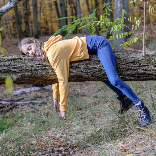 ein Mädchen hängt in Faultierpose über einem Ast
