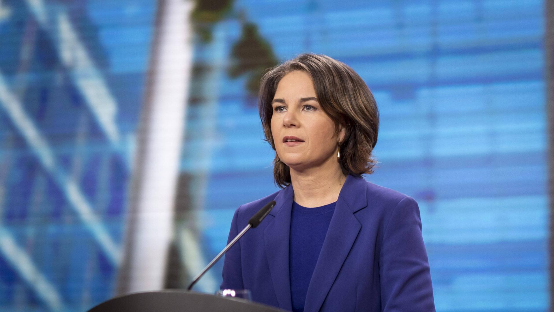 Außen-Ministerin Baerbock steht an einem Rede-Pult. Außen-Ministerin Baerbock steht an einem Rede-Pult.