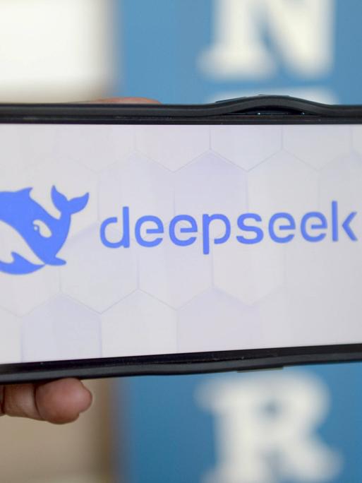 Eine Hand hält ein Smartphone auf dem das Logo der chinesischen KI Deepseek zu sehen ist.