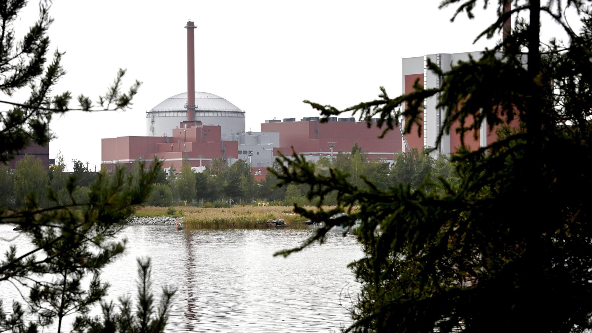 Blick durch Bäume auf das Atomkraftwerk von Olkiluoto in Finnland Blick durch Bäume auf das Atomkraftwerk von Olkiluoto in Finnland