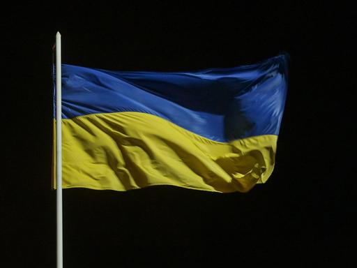 Eine blau-gelbe Flagge der Ukraine weht im Wind.