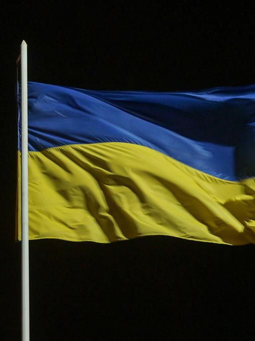 Eine blau-gelbe Flagge der Ukraine weht im Wind.