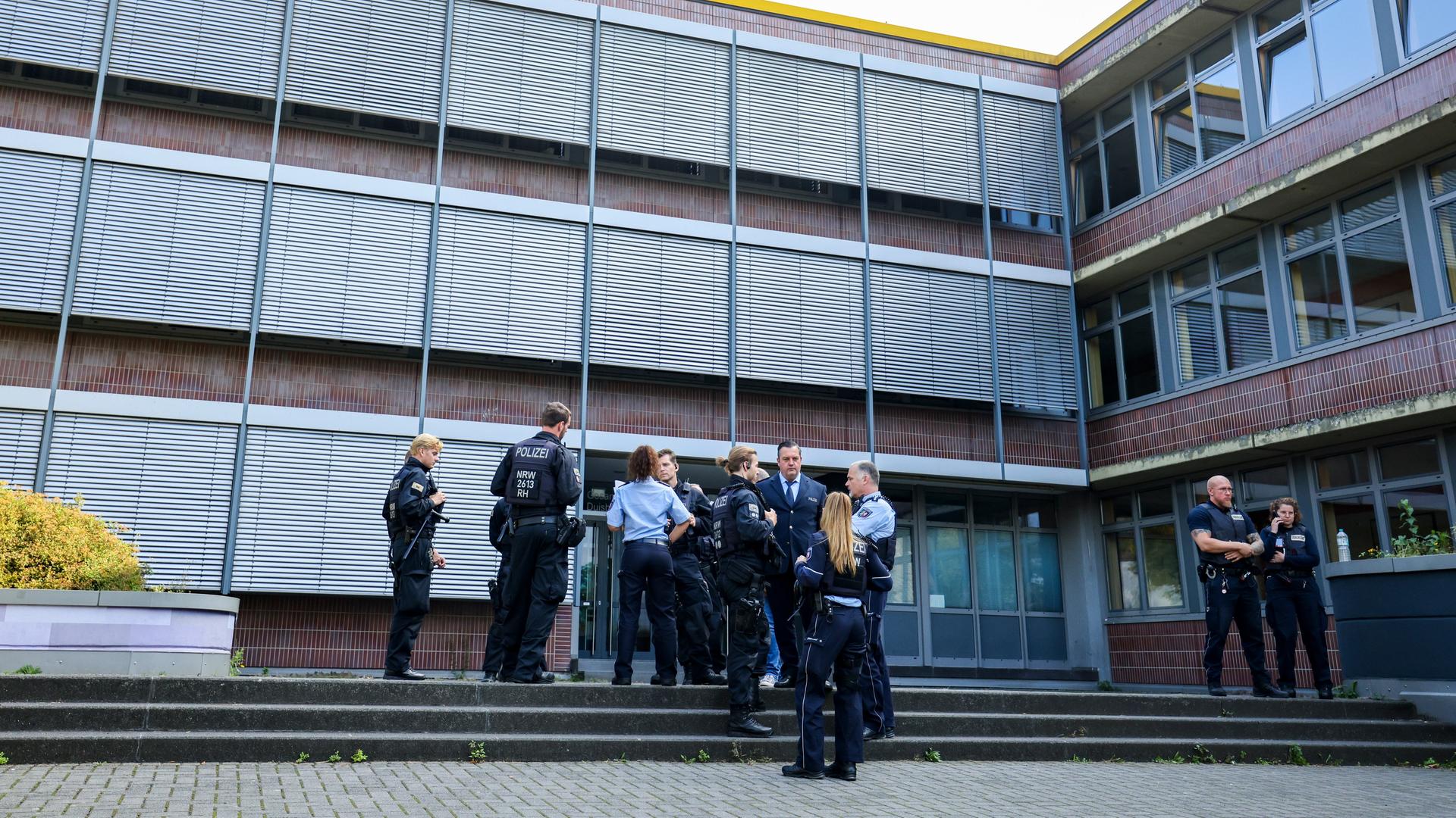 Duisburg: Beamte von Polizei und Ordnungsamt stehen vor der Gesamtschule Duisburg Mitte in Neudorf und sprechen mit Schulangestellten. 