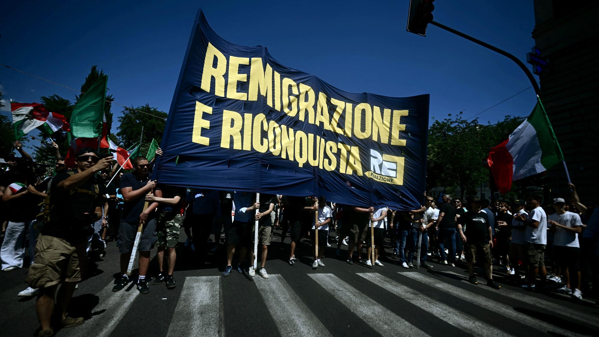 Demonstranten halten in Italiens Hauptstadt Rom bei einer Protestkundgebung, bei der die Rückführung von Migranten gefordert wird, ein Transparent mit der Aufschrift „Remigration und Rückeroberung“ hoch. Demonstranten halten in Italiens Hauptstadt Rom bei einer Protestkundgebung, bei der die Rückführung von Migranten gefordert wird, ein Transparent mit der Aufschrift „Remigration und Rückeroberung“ hoch.