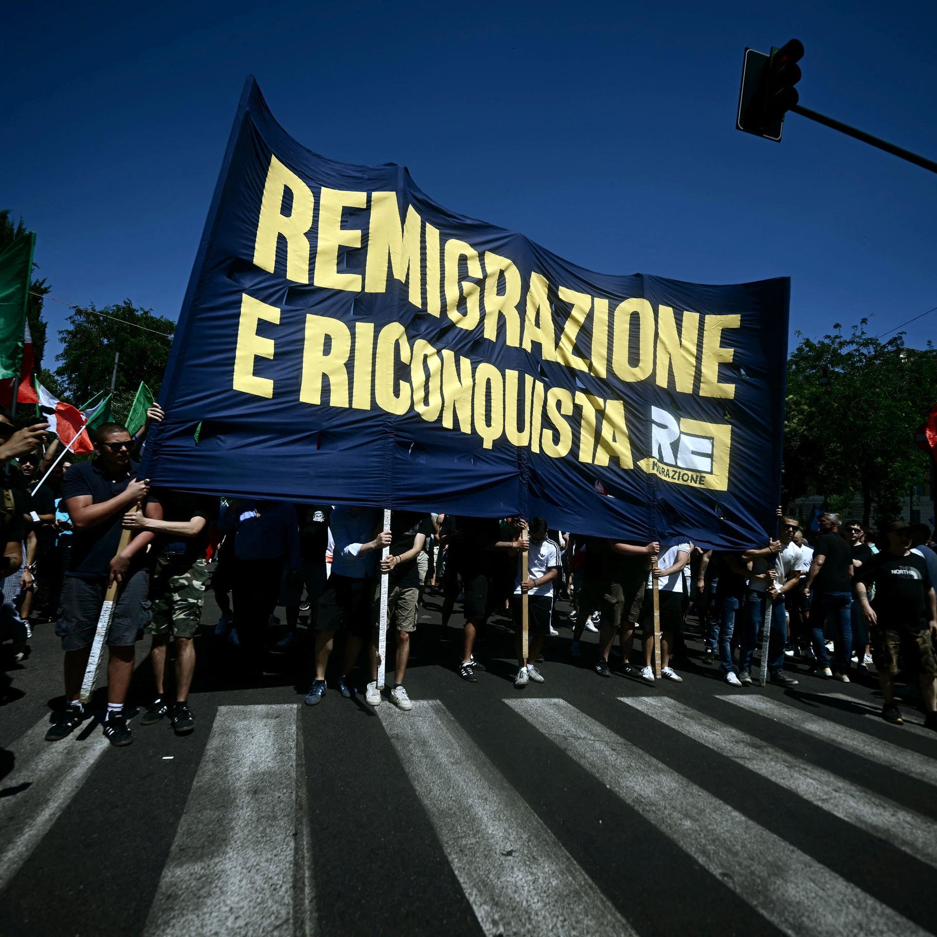 Demonstranten halten in Italiens Hauptstadt Rom bei einer Protestkundgebung, bei der die Rückführung von Migranten gefordert wird, ein Transparent mit der Aufschrift „Remigration und Rückeroberung“ hoch. 