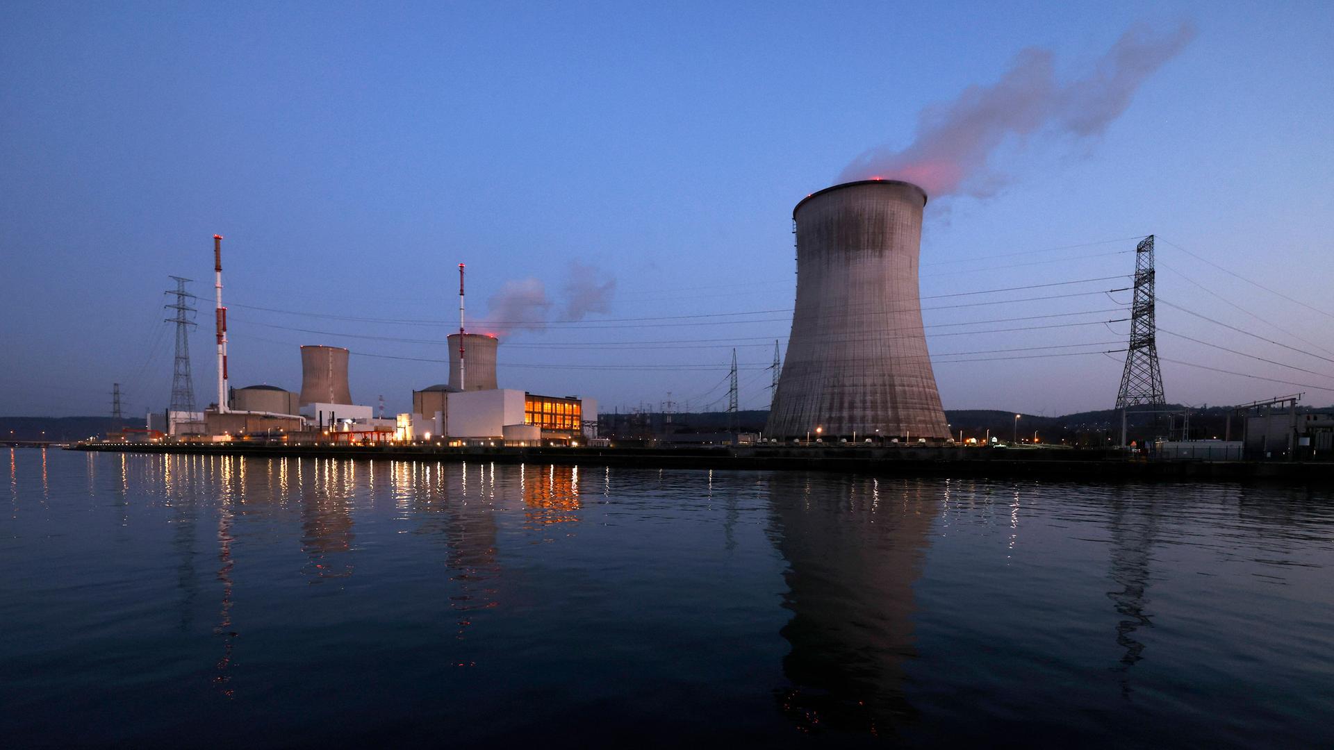 Das Kernkraftwerk Tihange bei Huy in Belgien nahe der deutschen Grenze im Abendlicht. Davor fließt die Maas, darin spiegelt sich unter anderem der Kühlturm.