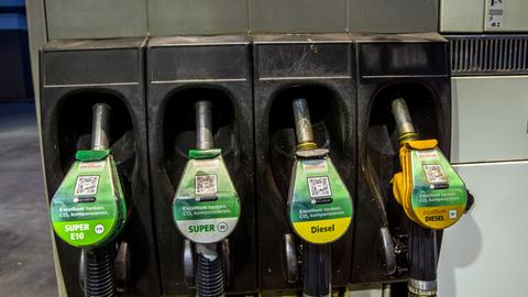 Zapfpistolen für die Kraftstoffe Benzin Super E10, Benzin Super E5, Diesel und excellium Diesel hängen an einer Zapfsäule 