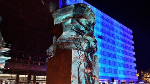 In Chemnitz werden die Büste von Karl Marx und Gebäude mit blauem Licht und Mustern angestrahlt.