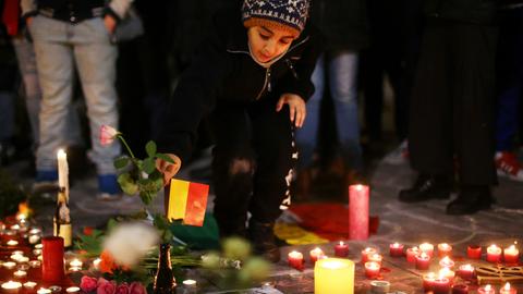 Ein kleines Kind legt nach den Terroranschlägen am 22. März 2016 in Brüssel eine Blume auf der Place de la Bourse nieder. Nach offiziellen Angaben kamen 32 Menschen aus 22 Ländern ums Leben, dazu drei der Attentäter, und mehr als 300 wurden verletzt.