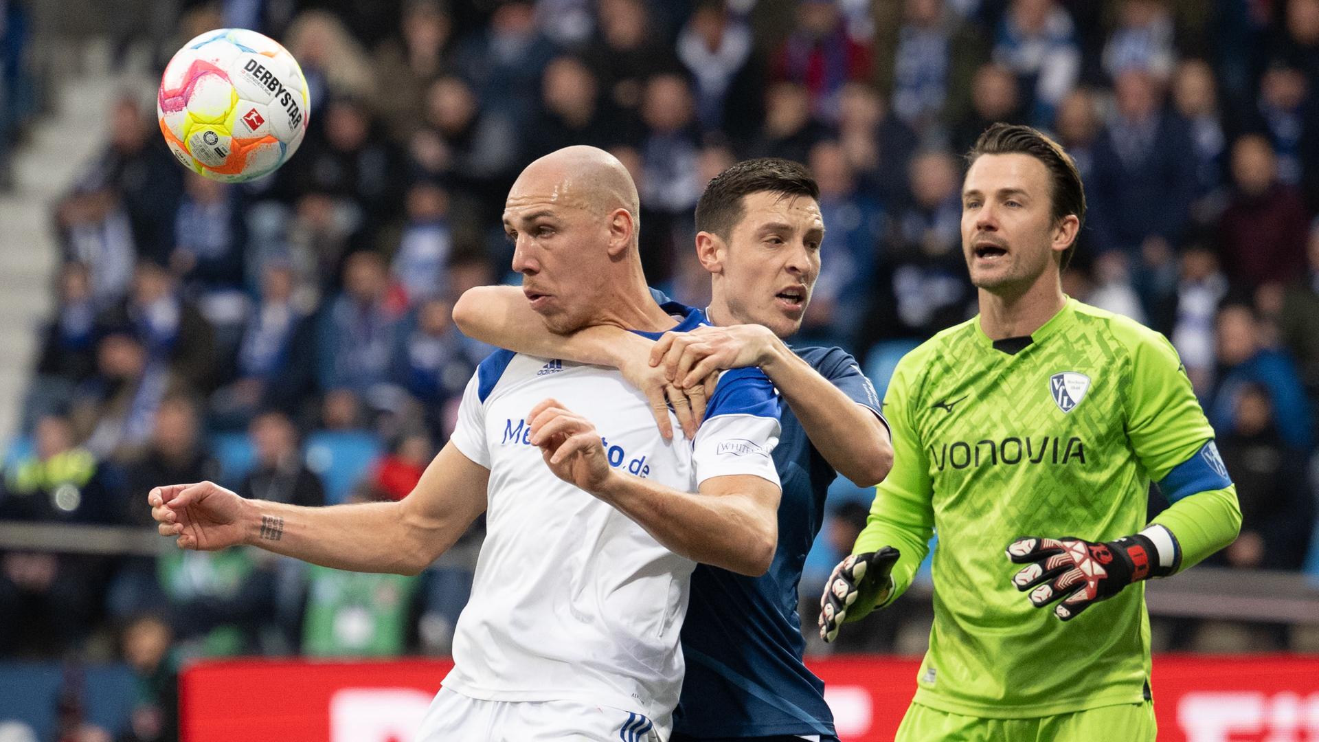 Frey im weißen Trikot köpft den Ball, Schlotterbeck im blauen Dress legt von hinten den Arm um Freys Hals. Hinter den beiden Riemann im grünen Trikot. Im Hintergrund unscharf Zuschaueru auf der Tribüne. Frey im weißen Trikot köpft den Ball, Schlotterbeck im blauen Dress legt von hinten den Arm um Freys Hals. Hinter den beiden Riemann im grünen Trikot. Im Hintergrund unscharf Zuschaueru auf der Tribüne.