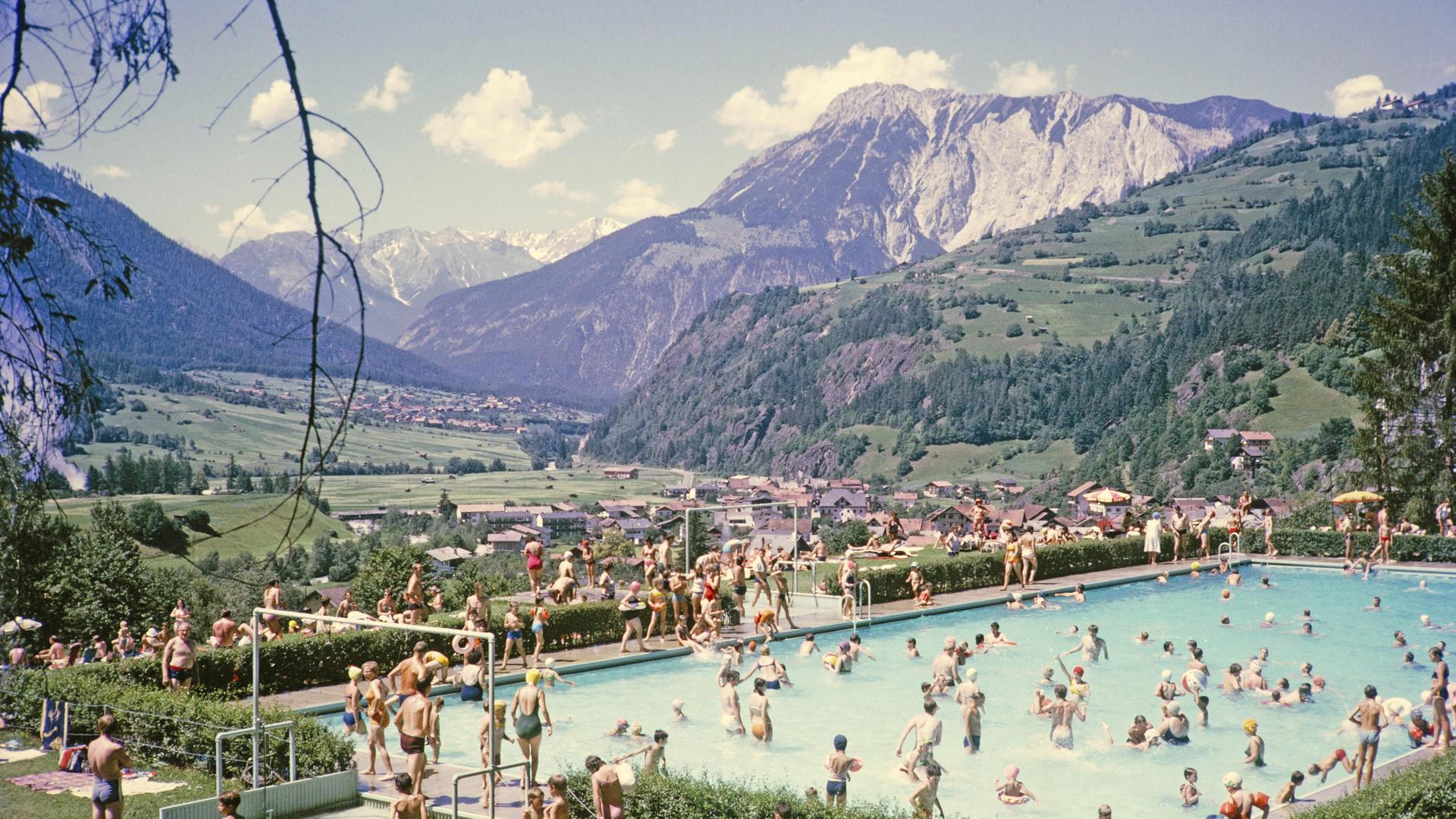 Gut gefülltes Schwimmbad vor der Kulisse der Alpen an einem sonnigen Sommertag Ötz in Österreich. Historische, kolorierte Postkarte. Gut gefülltes Schwimmbad vor der Kulisse der Alpen an einem sonnigen Sommertag Ötz in Österreich. Historische, kolorierte Postkarte.