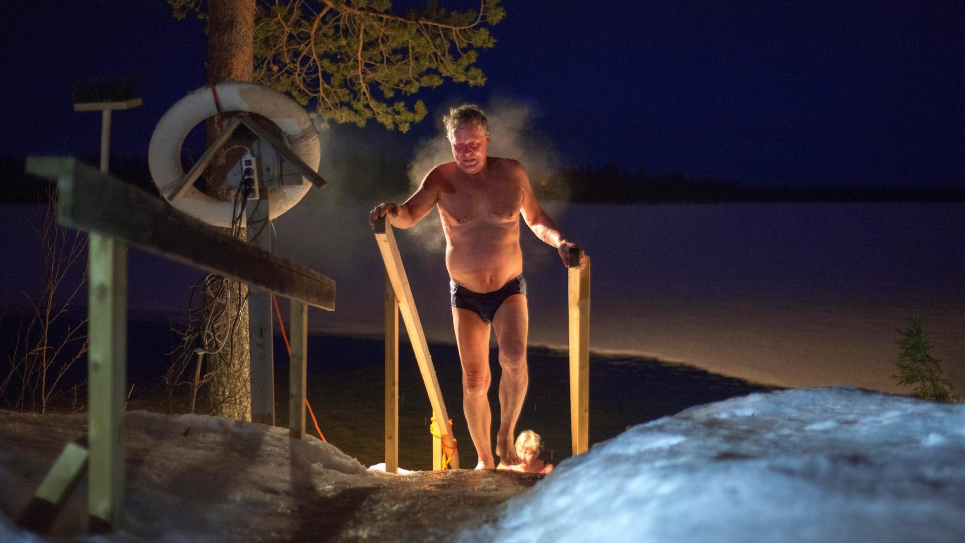 Ein dampfender Mann nach einem Saunagang in der kalten Nachtluft Lapplands