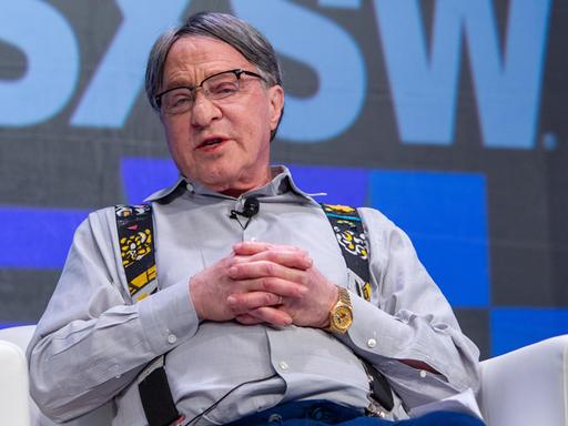 Ray Kurzweil sitzt auf einem Sessel auf einer Bühne und spricht zu seinem Gegenüber. Ray Kurzweil sitzt auf einem Sessel auf einer Bühne und spricht zu seinem Gegenüber.