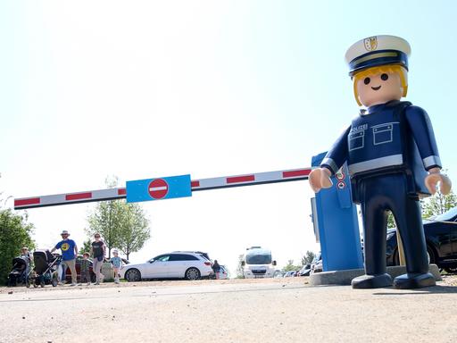 Ein Playmobil-Polizist steht an einer Zufahrtsschranke zu einem Parkplatz des Playmobil-Fun-Parks in Zirndorf