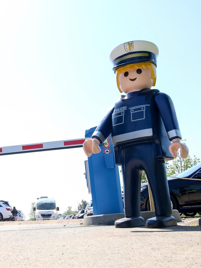 Ein Playmobil-Polizist steht an einer Zufahrtsschranke zu einem Parkplatz des Playmobil-Fun-Parks in Zirndorf