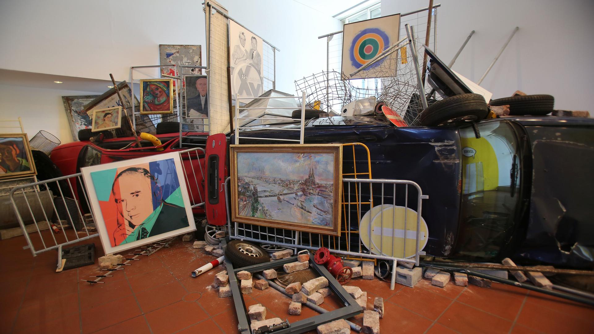 Die Installation "Bakunin's Barricade" von Ahmet Ögüt bestehend aus Absperrgittern, einem Auto, Straßenschildern und Kunstwerken