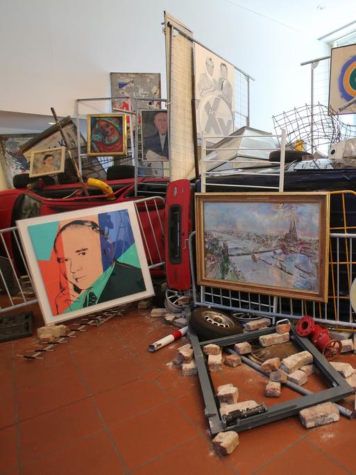 Die Installation "Bakunin's Barricade" von Ahmet Ögüt bestehend aus Absperrgittern, einem Auto, Straßenschildern und Kunstwerken