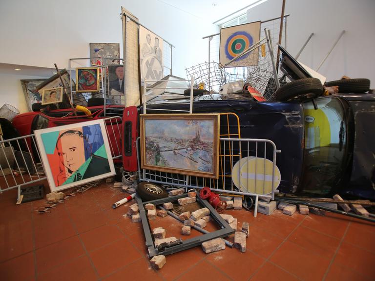 Die Installation "Bakunin's Barricade" von Ahmet Ögüt bestehend aus Absperrgittern, einem Auto, Straßenschildern und Kunstwerken